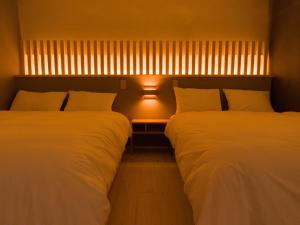 two beds sitting next to each other in a room at Forest Japandi House in Osaka