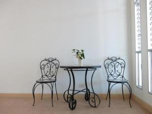 two chairs and a table in a room at The Passion Hotel in Chiang Mai