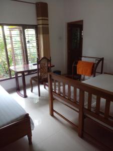 a room with a bed and a table and chairs at Muthu Villa in Kalutara