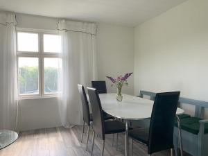 a dining room table with chairs and a vase of flowers on it at Flähult 107B in Ullared
