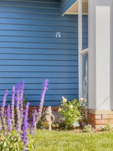 a blue house with purple flowers in front of it at Hazel House Ballarat in Wendouree +26 photos