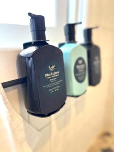 three bottles of detergent sitting on a bathroom shelf at Hazel House Ballarat in Wendouree
