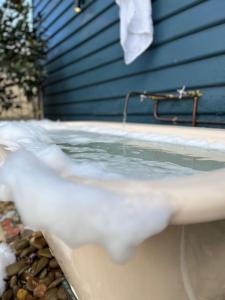 a bath tub filled with water next to a house at Hazel House Ballarat in Wendouree