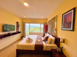 a bedroom with a large bed with a large window at Kodai Elliott in Kodaikānāl