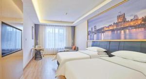 a hotel room with two beds and a painting on the wall at Vienna Hotel Beijing Fangshan District Guangyangcheng Metro Station in Wangzhuang