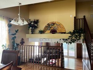 a living room with a staircase and a chandelier at greenview mck sunny room in Calgary