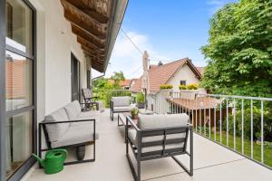 a patio with chairs and a table on a balcony at Fe Wo Brunnen - 120 qm -Quiet location - lots of nature - grosser Balkon und Garten - 3D Rundgang verfügbar in Memmingen