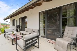 a patio with chairs and a table and windows at Fe Wo Brunnen - 120 qm -Quiet location - lots of nature - grosser Balkon und Garten - 3D Rundgang verfügbar in Memmingen