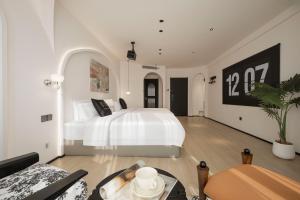 a bedroom with a white bed and a table at Town Designer B&B in Qingdao