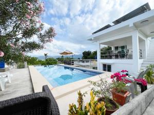 a villa with a swimming pool and a house at Villa Bor a Mar - Holiday homes in Puerto Galera