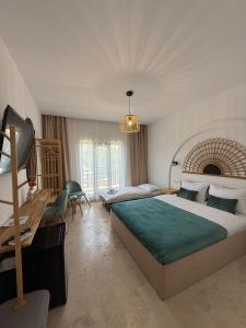 a hotel room with a large bed and a desk at Muse 2Mai in 2 Mai