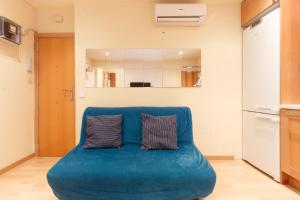 a blue couch with two pillows on it in a room at Apartment Bed&BCN Sant Andreu II in Barcelona