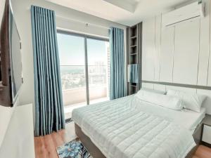 a bedroom with a large bed and a large window at Toà nhà Pull Man in Quy Nhon