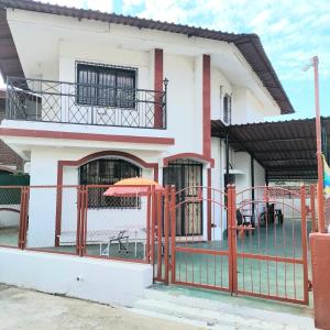 a house with a fence and an orange umbrella at Villa De Quads in Lonavala