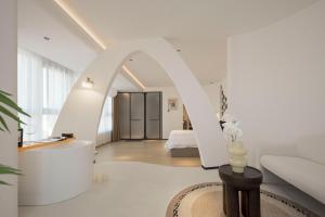 a white room with a bed and a bathroom at Town Designer B&B in Qingdao