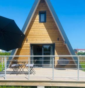 a house with a thatched roof with a deck at Lodge lady tipi 1 avec bain nordique et piscine in Saint-Utin