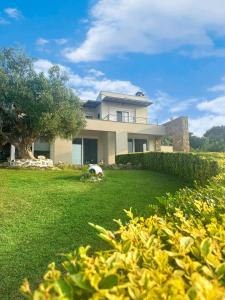 a house with a green yard in front of it at Sunrise Villa in Kassandria