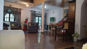 una sala de estar con un sofá y una mesa en Villa rajagiriya, en Nikawatawana