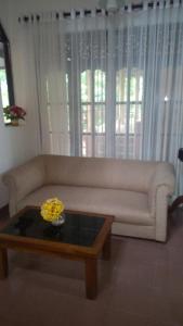 Una sala de estar con un sofá y una mesa de café. en Villa rajagiriya, en Nikawatawana