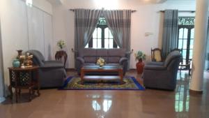 Una sala de estar con dos sofás y una mesa de café. en Villa rajagiriya, en Nikawatawana