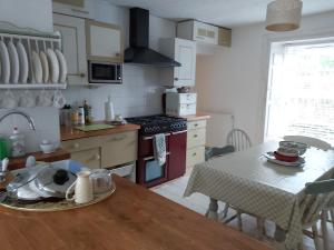 une cuisine avec une table et une cuisinière four supérieur dans l'établissement Charming Cottage For Share ,Private Double Room , Fast Fibre Optik Int, Free Parking, Garden, à Édimbourg