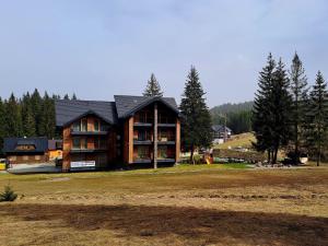 a large log house on a field with trees at Apartmán 31 - Villa Erdődy Resort in Oravská Lesná