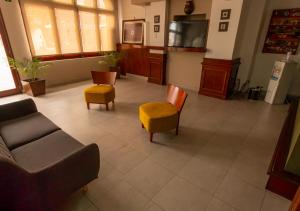 a living room with a couch and chairs and a tv at Hotel Shauard in Salta