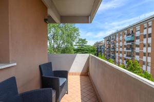 a balcony with chairs and a view of buildings at LA MAR Apartment Viareggio in Spinea