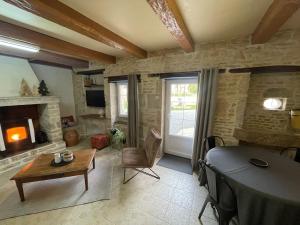 a living room with a table and a fireplace at La petite maison d a cote in Champniers +22 photos