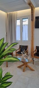 ein Wohnzimmer mit einem Glastisch und einer Pflanze in der Unterkunft Verani suites Lefkas Town in Lefkada Town