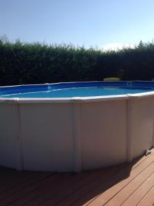a hot tub with a blue top on a deck at MAISON PRIVÉE AVEC PISCINe in Beaurepaire