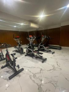 a group of exercise bikes in a room with a marble floor at Bujalux apartment in Muscat