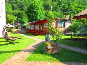 a small house in a yard with a bench and a house at Cabana Ogradena in Eşelniţa