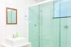 a bathroom with a glass shower and a sink at Recanto do Jack in Búzios