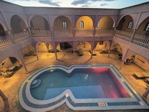 an indoor swimming pool in a building with aasteryasteryasteryasteryasteryasteryastery at Maison Merzouga Guest House in Merzouga