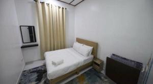 a small room with a bed and a tv at OYO 90976 Pantaistay@baturakit in Kuala Terengganu +24 photos