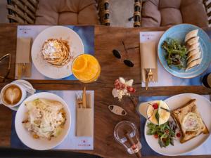 a wooden table with plates of food on it at Sagredo Boutique Hotel & Spa in Ágios Fokás