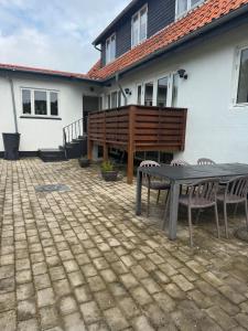a patio with a table and chairs in front of a house at Bøtø strand feriehus 1 in Marielyst