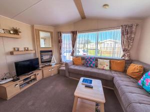 a living room with a couch and a tv at Great 4 Berth Caravan With Wheelchair Access In Suffolk, Ref 68129Bs in Lowestoft