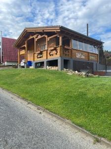 a large wooden house with a lawn in front of it at Bergzauber Hütte in Langelsheim