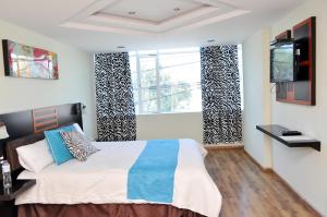 1 dormitorio con cama y ventana grande en Hotel de las Américas - Ambato, en Ambato