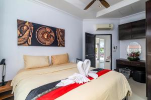 a bedroom with a bed and a painting on the wall at Luxurious & Quiet Pool Villa Orchid in Nai Yang Beach +14 photos