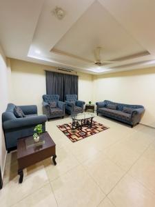 a living room with couches and a coffee table at Bahria Heights 1 in Dargai