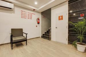 a chair in an empty room with a stair case at Townhouse 359 Begumpet Near Hyderabad Central in Hyderabad