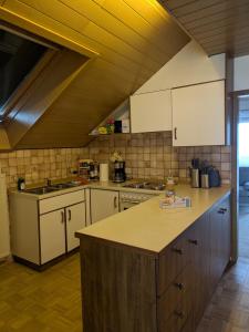 Una cocina con gabinetes blancos y encimera. en Ferienwohnung Gerstetten 85 qm - 2 Schlafzimmer - Küche mit großem Essbereich - Wohnzimmer - Balkon - Bad - ruhige Lage, en Gerstetten