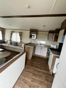 a kitchen and living room of an rv at 166 unity beach central location sleeps 8 pet friendly caravan in Brean +4 photos
