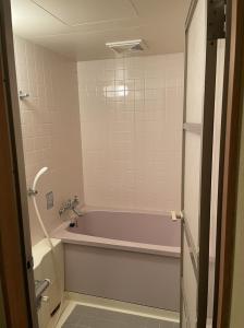 a bathroom with a pink tub and a sink at Tsubame Highland Lodge燕ハイランドロッジ in Myoko +45 photos