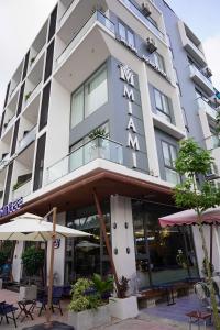 Ðông KhêにあるMiami Luxury Apartment Hai Phongのホテルの前にテーブルとパラソルがあります。
