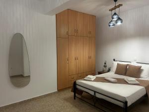 una camera da letto con un letto grande e uno specchio di My lithos a Ios Chora