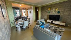 a living room with a couch and a table and a tv at Kigo Close Apartments in Kigo